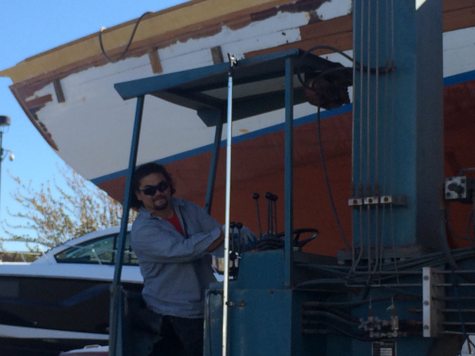 A crew member at the helm of the Merry Maiden, the classic 1946 Philip Rhodes design, navigating the waters of Puget Sound with characteristic Pacific Northwest charm and weathered grace.