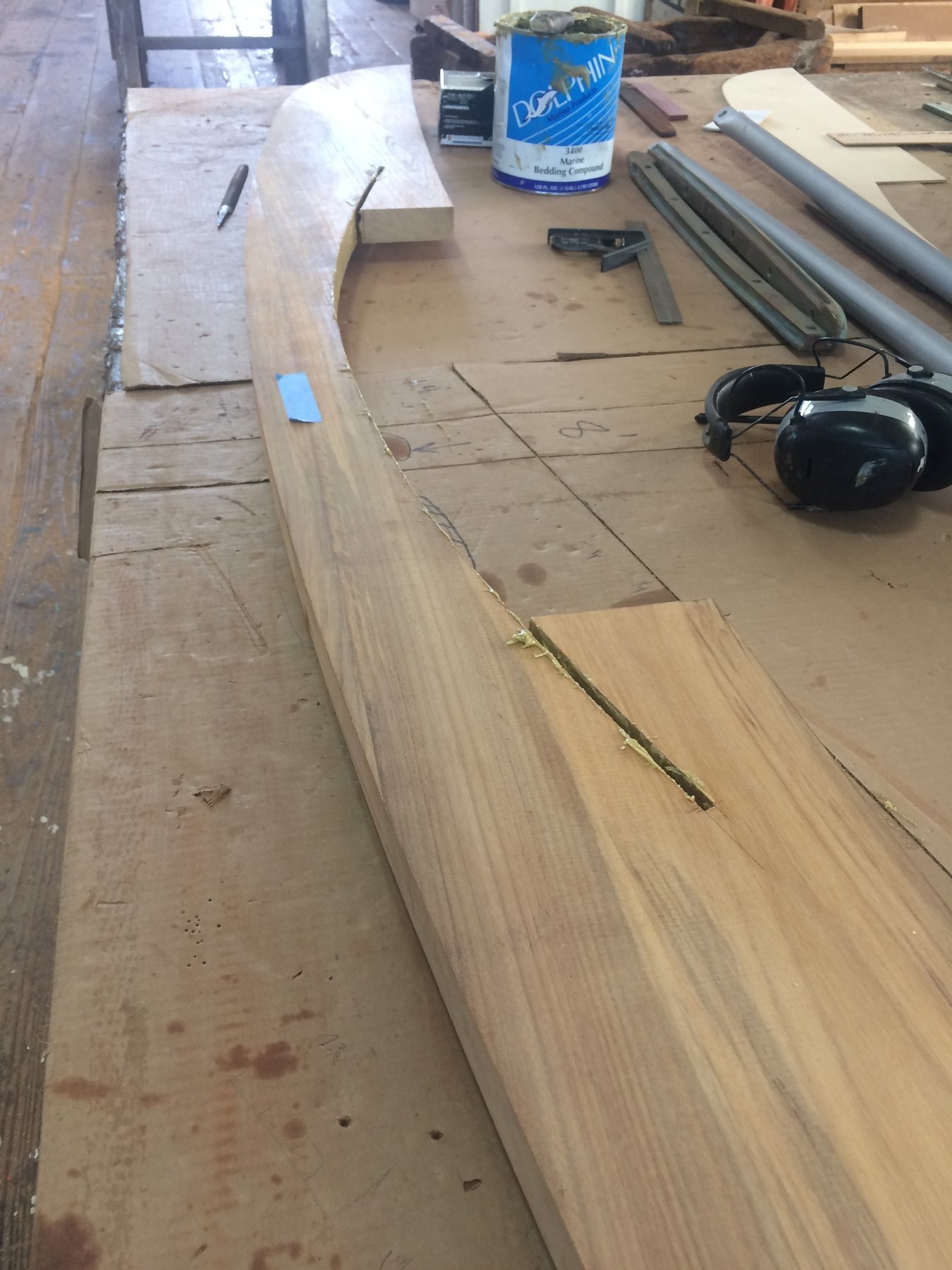 The graceful sheer line of classic 1946 Philip Rhodes design emerges during restoration work, revealing the elegant curves that define the Merry Maiden's timeless hull.