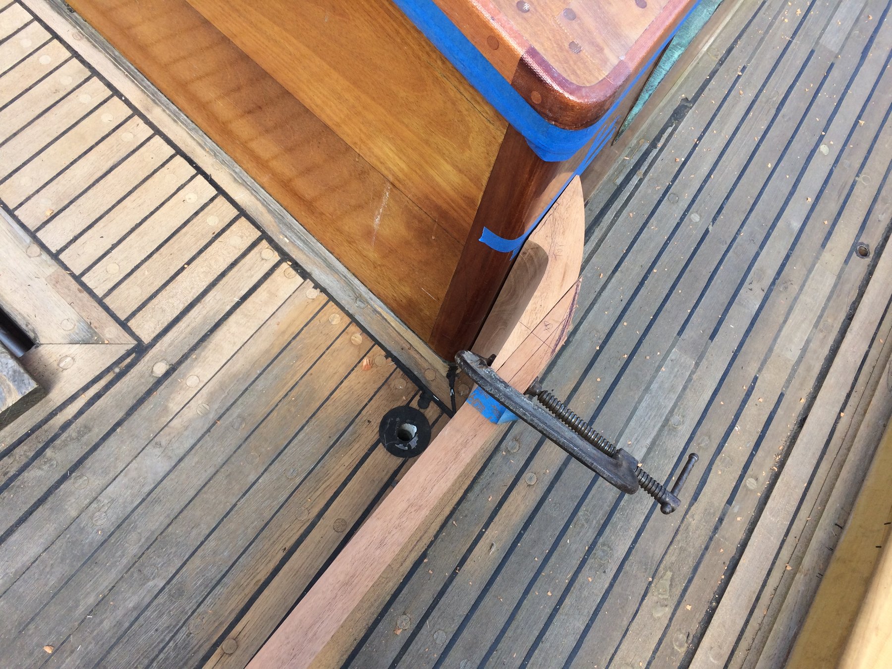 Overhead view of Merry Maiden's teak deck reveals the classic craftsmanship of this 1946 Rhodes design, with blue tape marking work areas and a well-worn wooden hull showing the patina of decades on the water.