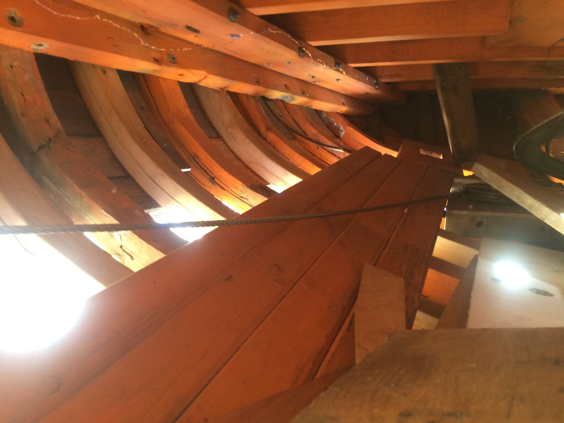 The elegant wooden ribs of Merry Maiden's hull are revealed in the boatyard, exposing the classic craftsmanship of this 1946 Philip Rhodes design during restoration work in Puget Sound.
