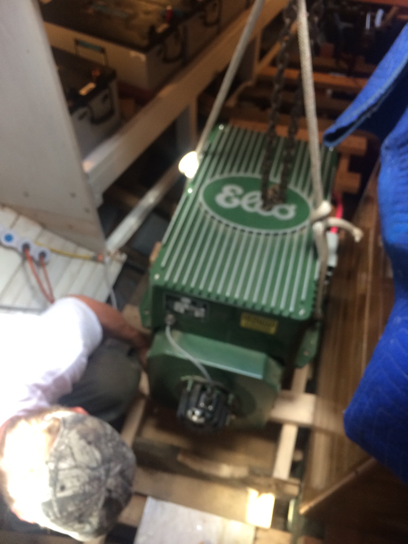 A crew member tends to the restored engine of the classic 1946 Philip Rhodes-designed Merry Maiden, showcasing the meticulous mechanical work that keeps this vintage yacht operational.