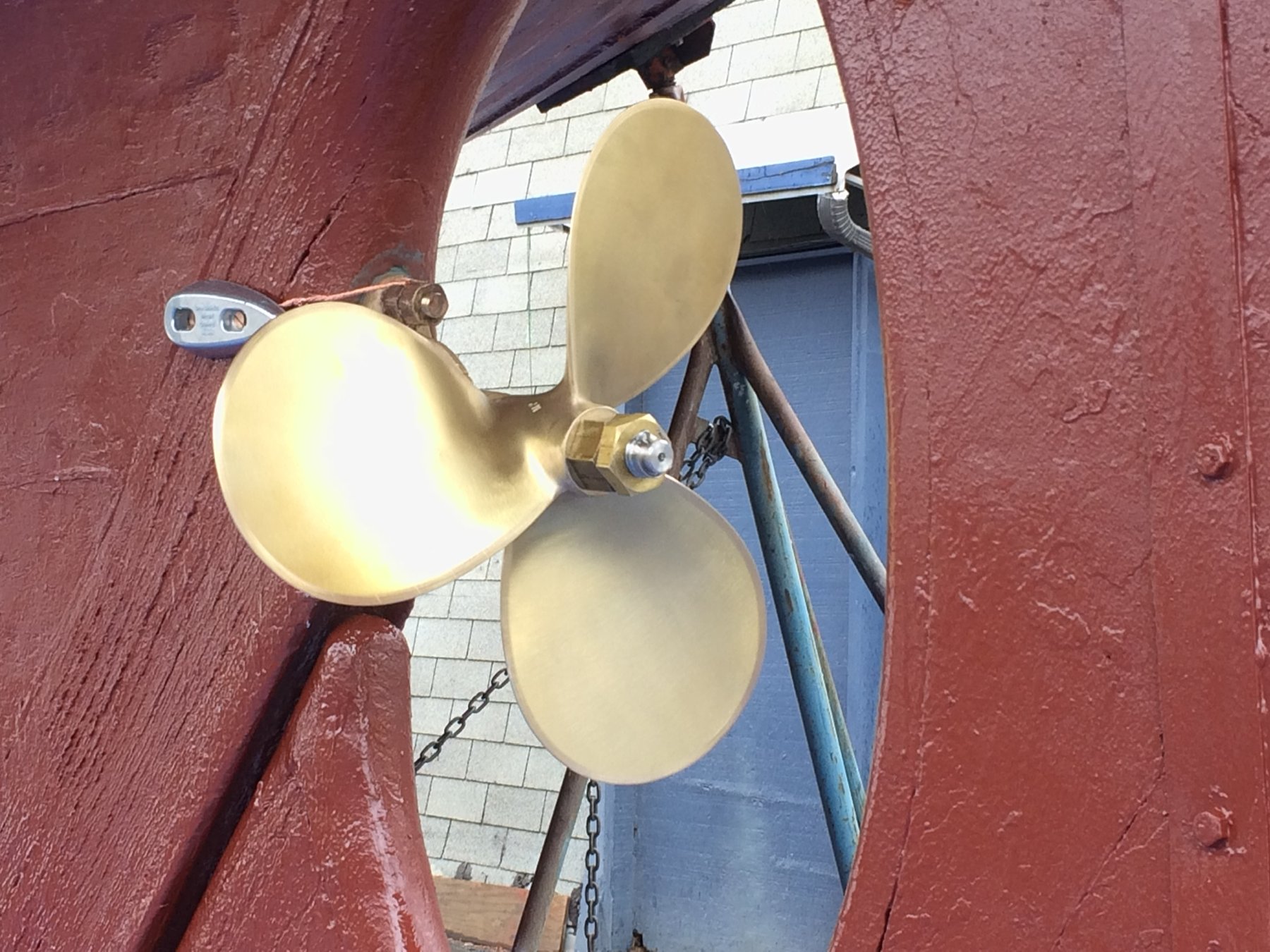 Brass signal bells gleam in the Pacific Northwest sun, mounted on the classic wooden hull of the 1946 Philip Rhodes-designed Merry Maiden, a testament to traditional maritime craftsmanship.