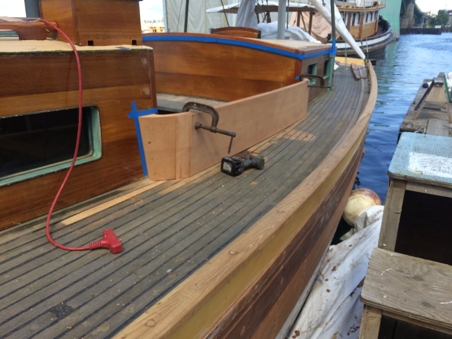The teak deck of classic yacht Merry Maiden gleams in Pacific Northwest sunlight, her traditional wooden construction and vintage hardware testament to her 1946 Philip Rhodes design.