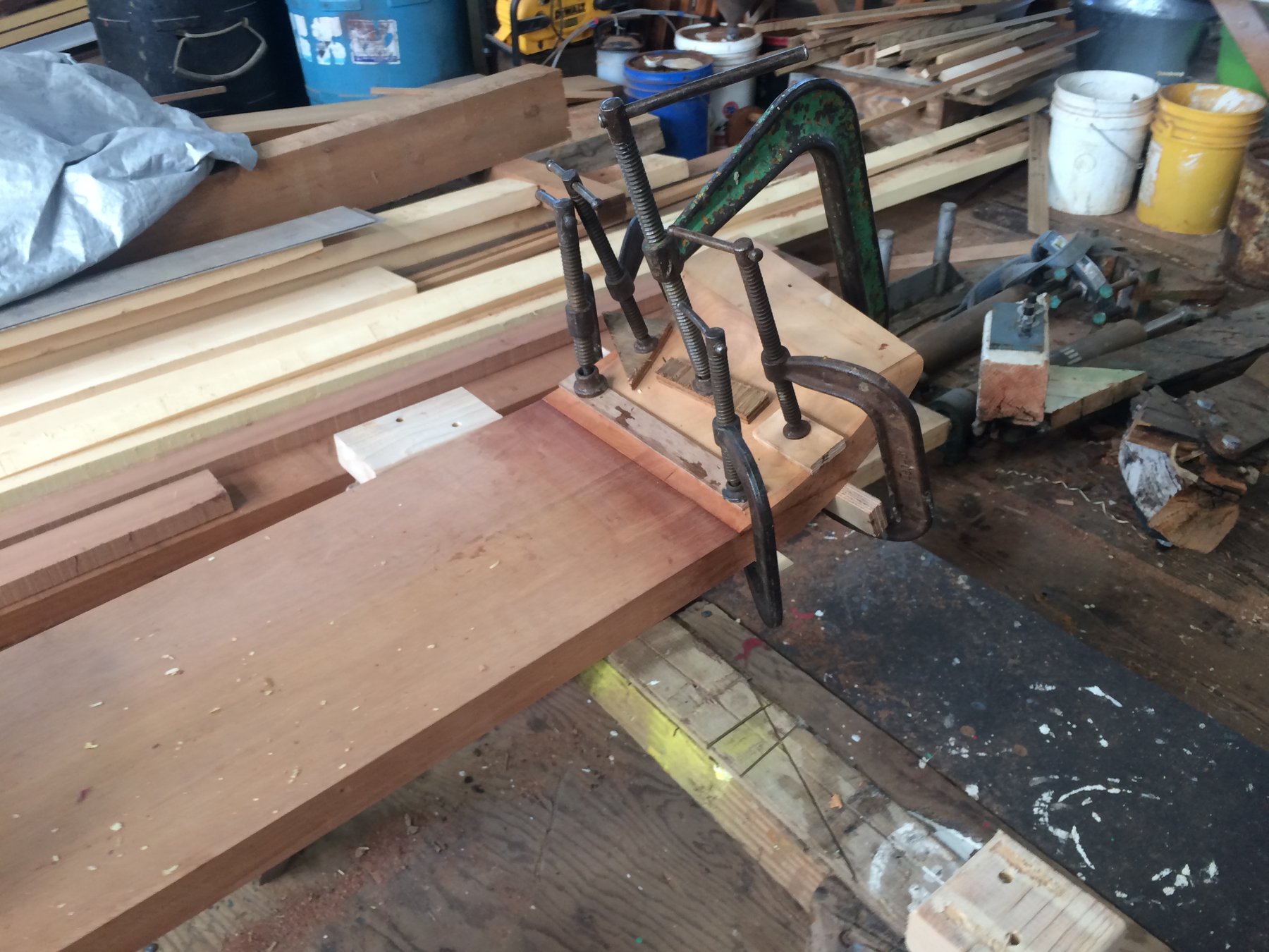 Classic wooden joinery takes shape in the restoration of Merry Maiden's deck, with traditional clamps and fixtures holding carefully fitted planks in a Puget Sound boatyard.