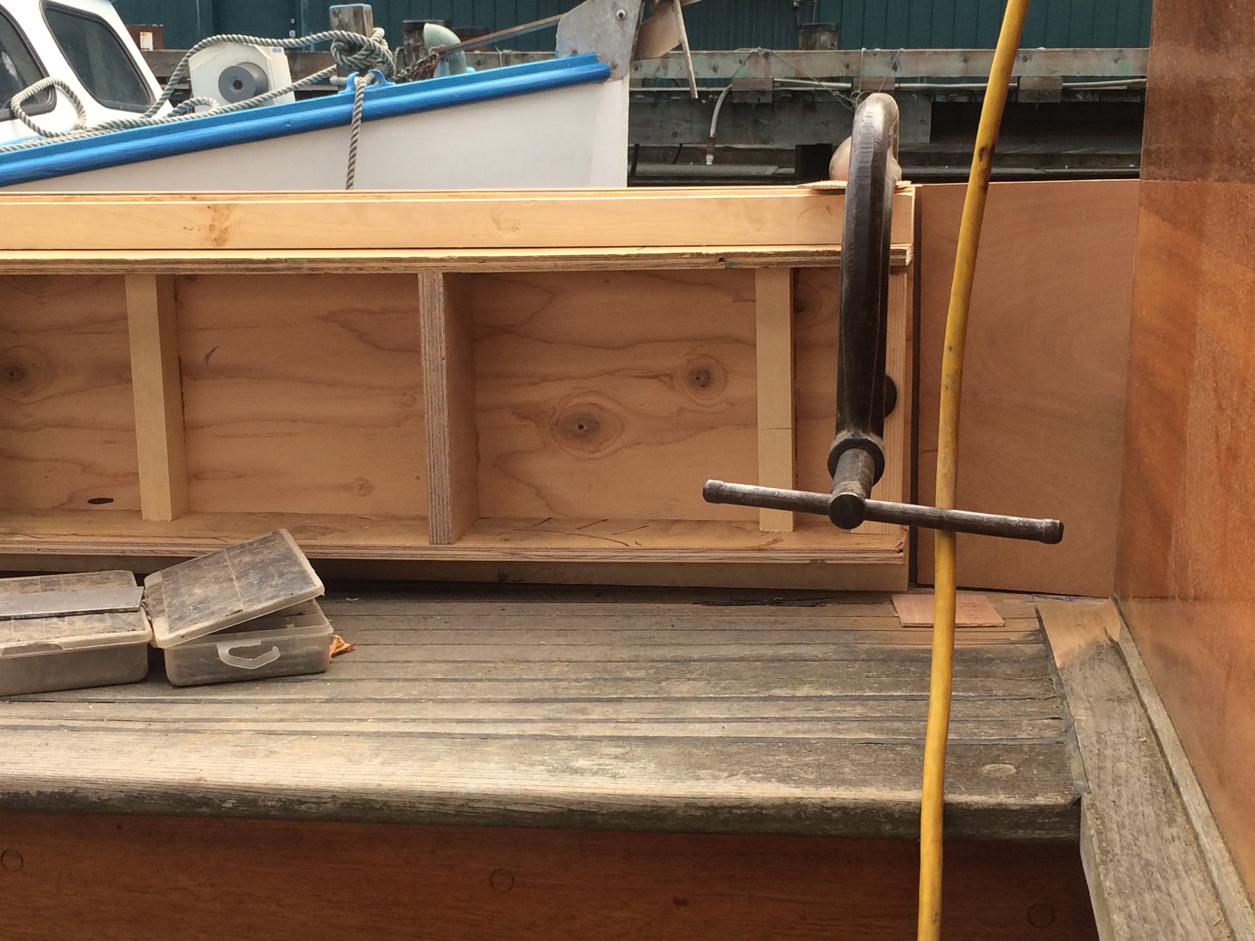 Interior woodwork of the classic 1946 Philip Rhodes-designed Merry Maiden shows fresh carpentry and storage compartments under restoration in a Puget Sound boatyard.