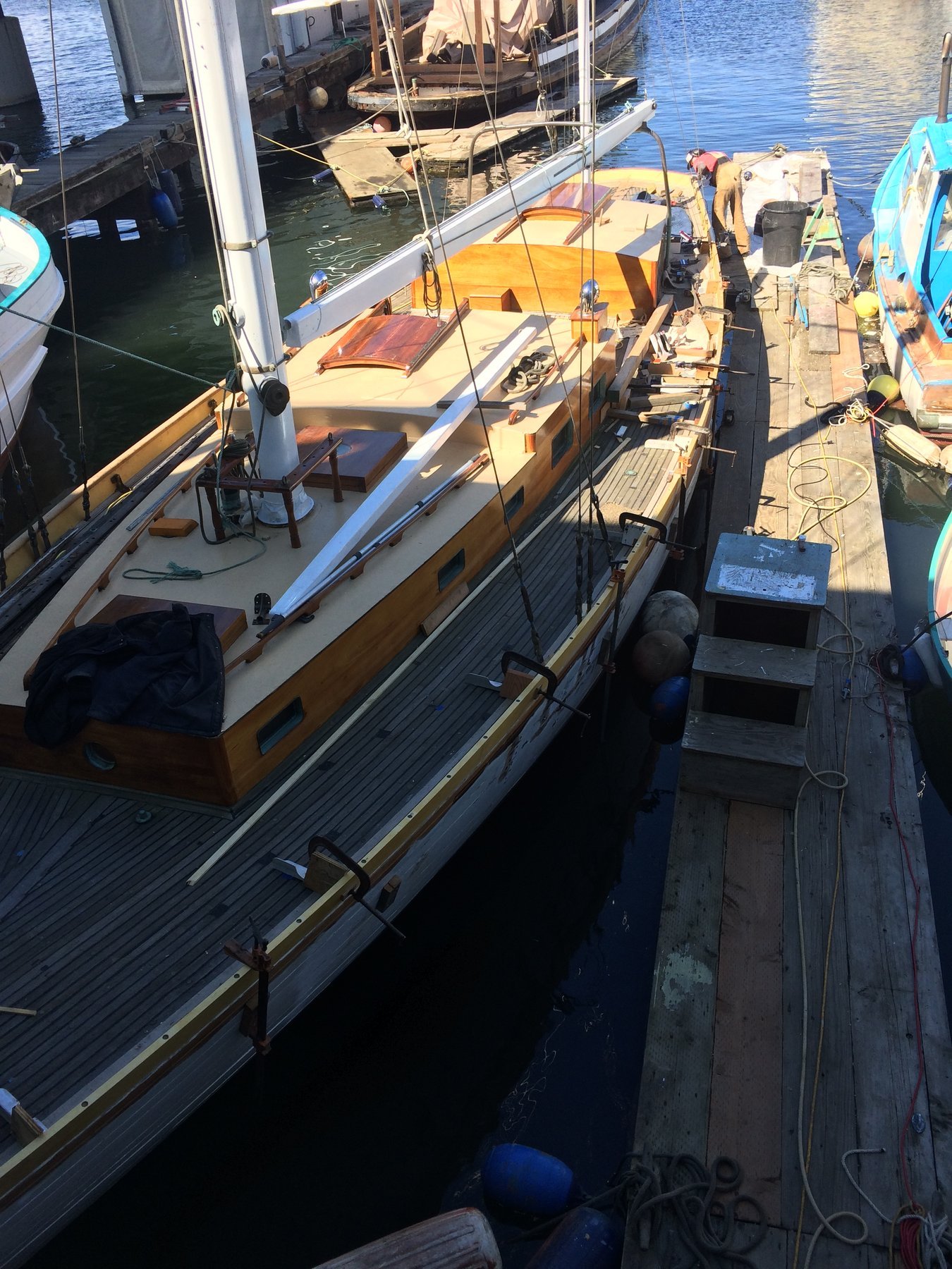 Merry Maiden, a classic 1946 Philip Rhodes design, rests peacefully at her Puget Sound mooring with golden afternoon light illuminating her traditional wooden hull and rigging.