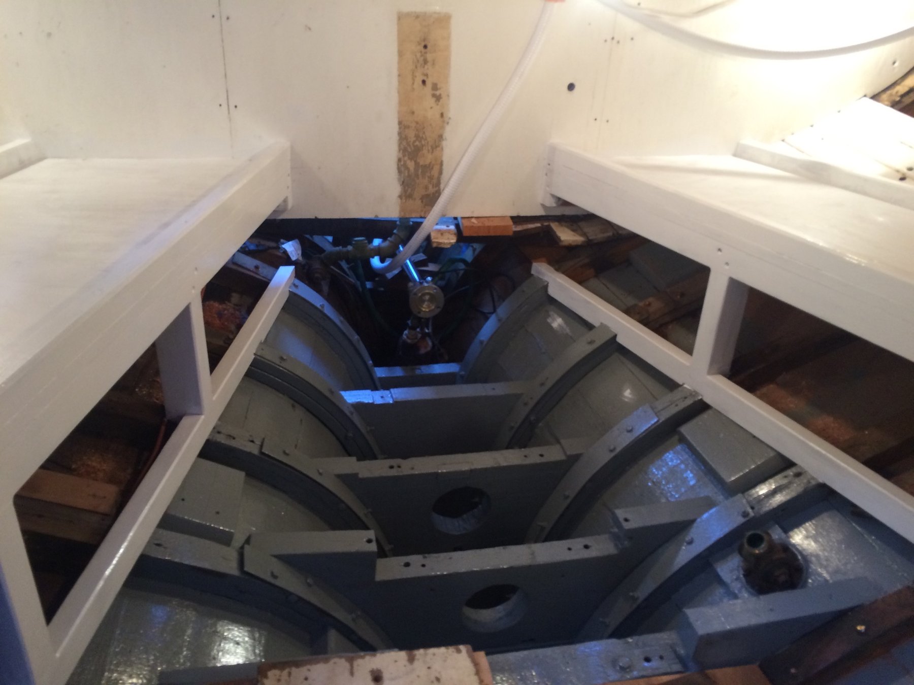 Interior hull structure of the Merry Maiden revealed during restoration, exposing the elegant wooden framing and dark interior planking of this 1946 classic yacht.