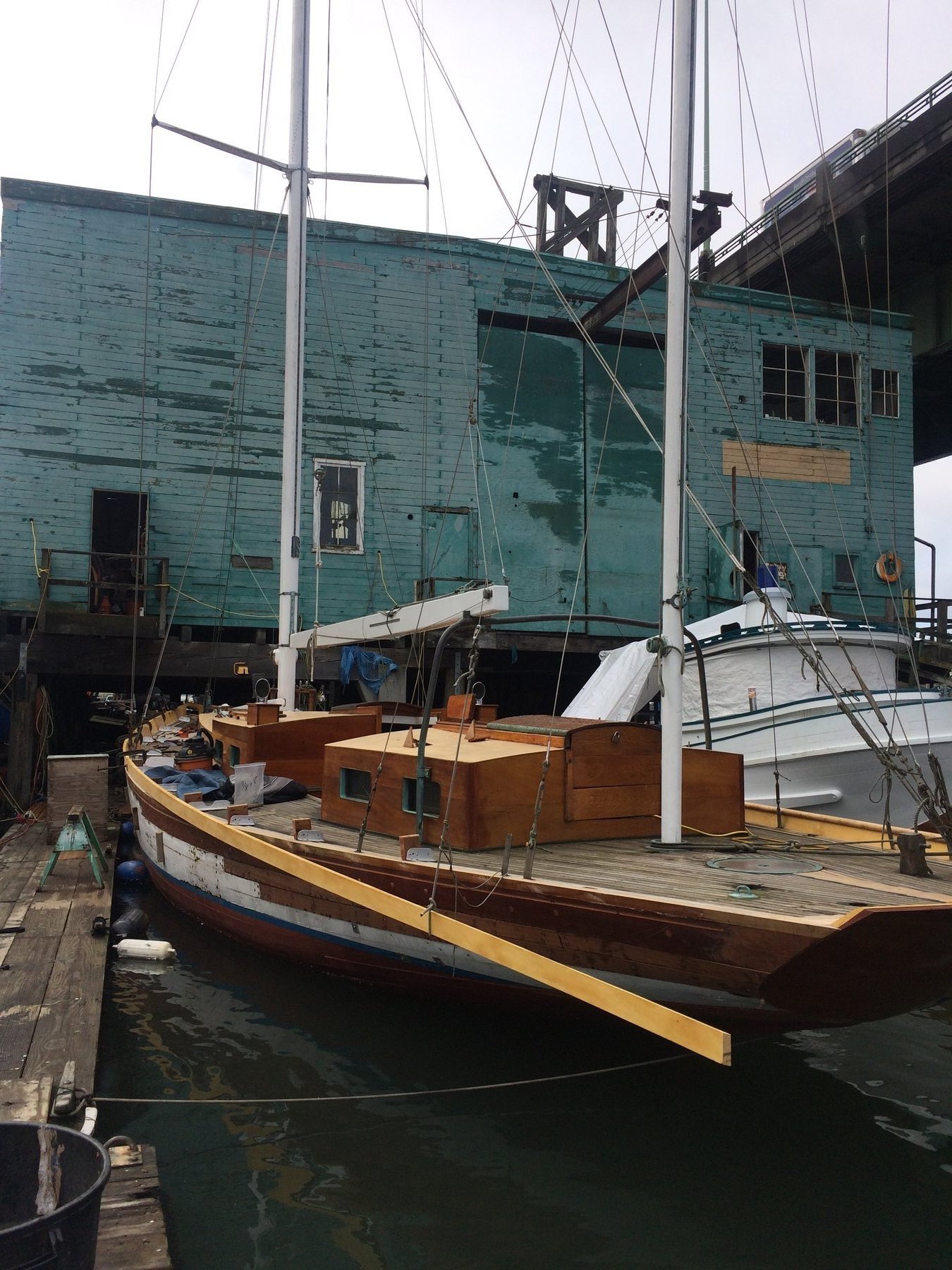 The classic 1946 Philip Rhodes-designed Merry Maiden sits moored in Puget Sound, her weathered hull and traditional rigging revealing decades of Pacific Northwest cruising and character.